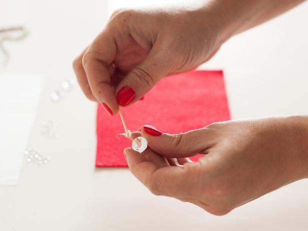 Attach the rhinestones from the middle of your design and work outwards, using a graph paper sketch as a rough guide. Use a toothpick to apply glue to the back of the center, large rhinestone.