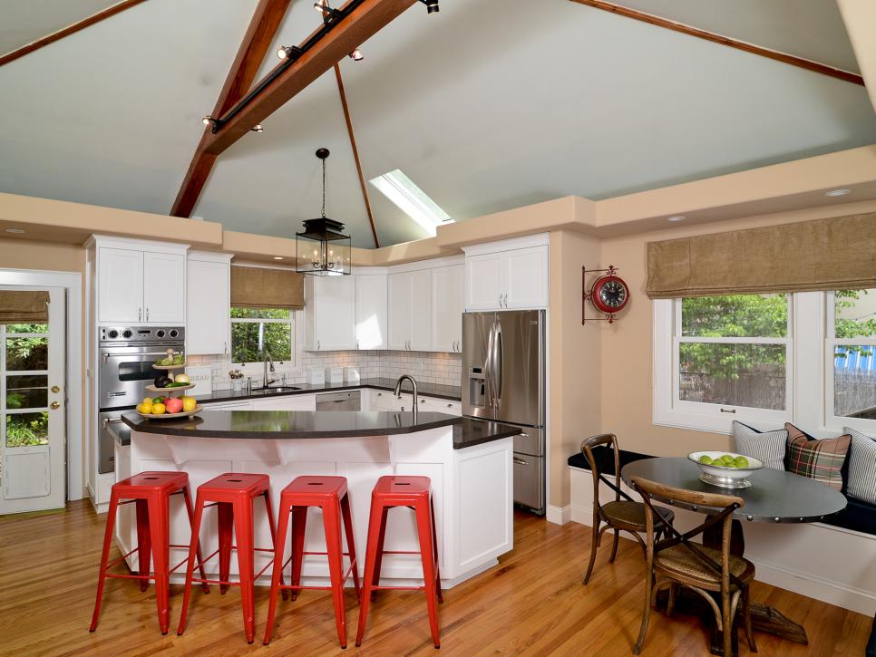 Neutral Contemporary Kitchen With Vaulted Ceiling and Red Barstools
