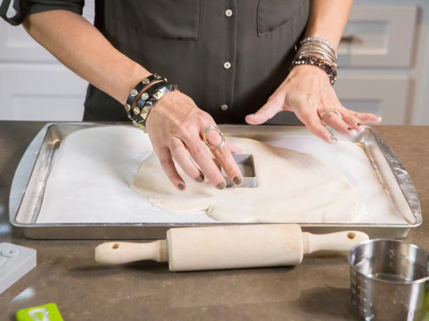 Designer Laurie March, who has a plan to transform the living room and foyer of TV personality Kendra Wilkinson and husband Hank Basketts (retired NFL player) into a glittering, disco-inspired Holiday wonderland, shows the secrets of DIY salt-dough cookie ornaments. Using an alphabet letter mold, she presses it into soft cookie dough to imprint the letter's shape in the dough, before flipping the mold and pressing it again to use its edges to cut arond the imprinted letter, which is then oven baked until it hardens, and finally spray painted, as seen on HGTV's Celebrity Holiday Homes.