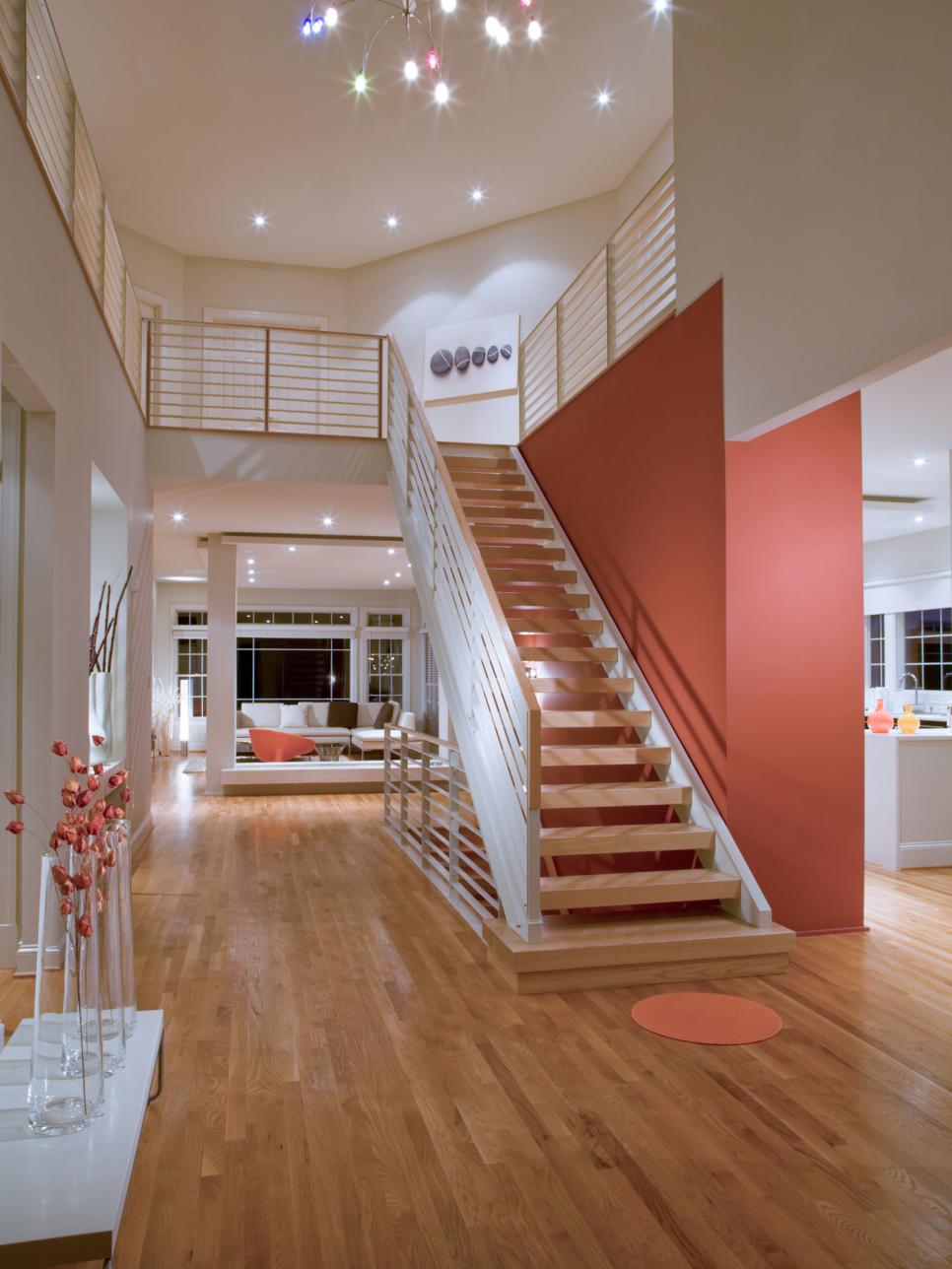 Neutral Foyer With Floating Stairs and Red Accent Wall
