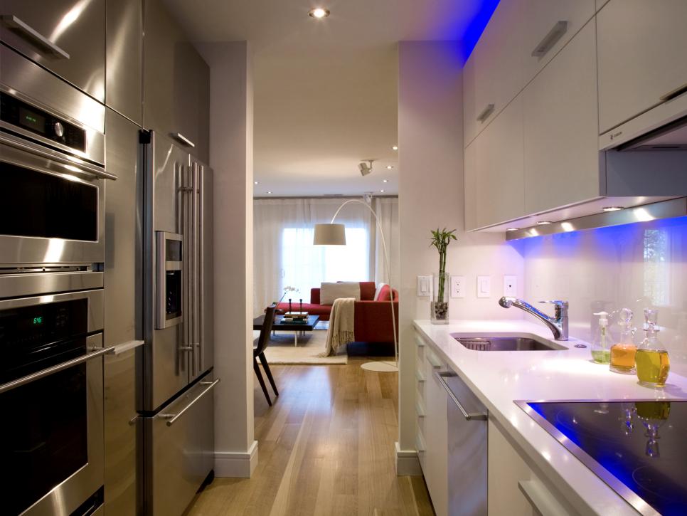 Galley Kitchen with White Cabinets, Blue Lighting and Stainless Steel Appliances