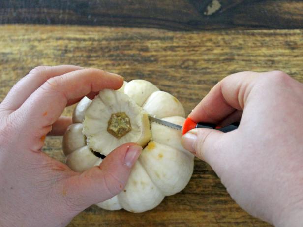 Pull out the top of the pumpkin, then scoop out the remaining seeds and flesh with a teaspoon.