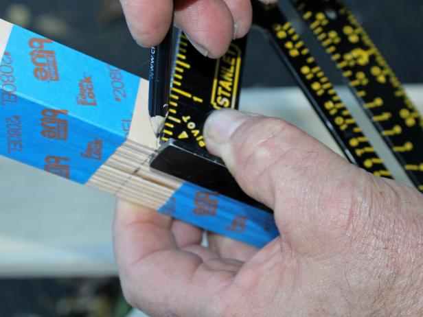 Once you've determined the proper measurements for your runner, bundle a group of 14 sticks together and secure with painter's tape. This will make it easier to cut pieces to size. Step two of this step-by-step project requires you to use a speed square or ruler, measure out the desired length and mark with a pencil.