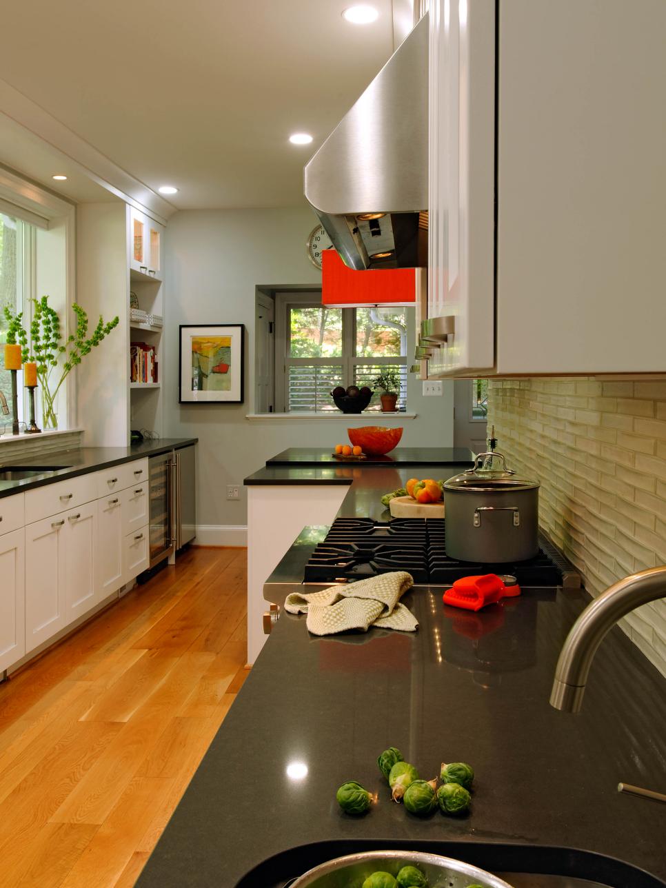 Contemporary Kitchen With White Cabinets, Black Quartz Counters and Red Accents