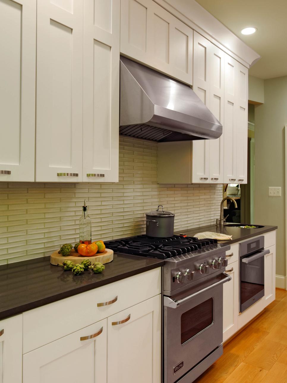 Kitchen With Limestone Backsplash and Stainless Steel Range Hood