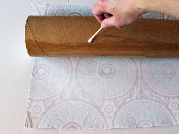 Wrap fabric around mailing tube and, if necessary, cut off any excess fabric at the tube's top and bottom. Working in small sections, apply adhesive to tube with a cotton swab or disposable brush then press fabric to tube and hold in place for a minute or so to allow glue to dry before attaching the next area.