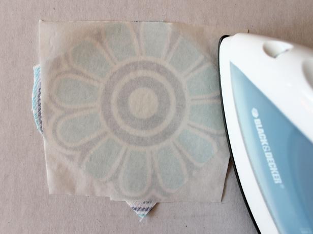 Cut a piece of fusible web that's approximately the same size as the fabric you're using for the no-sew Christmas ornament. Flip fabric over, place fusible web glue-side-down (has a slightly shiny, rough texture) and press for 5 to 8 seconds with a hot, dry iron