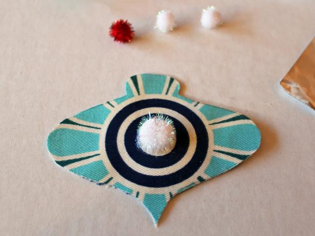 Embellish your ornament by adding a small amount of glue then attaching pom-poms, sequins or upholstery trim.