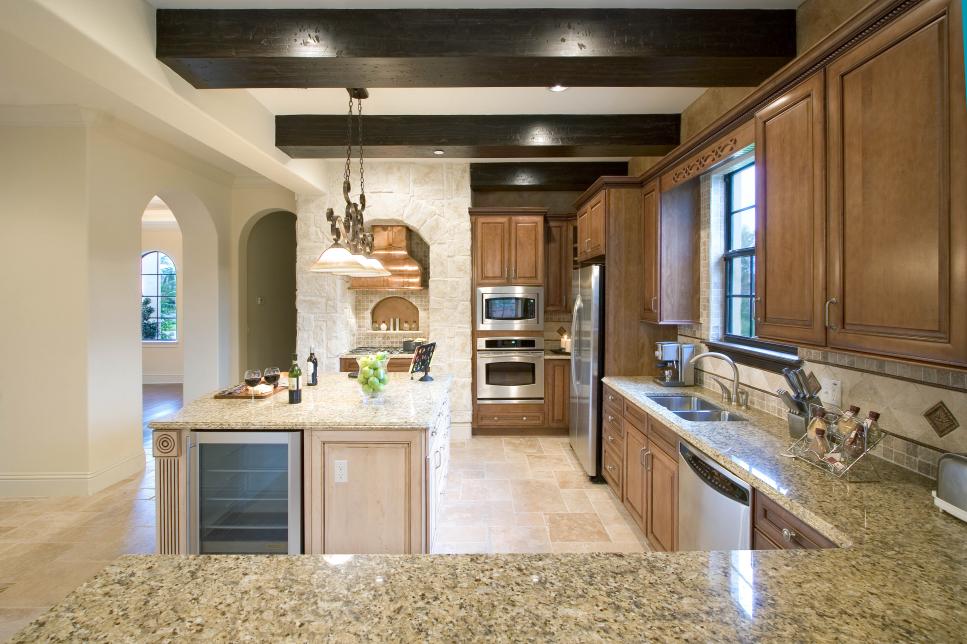 Neutral Mediterranean Kitchen With Warm Wood Cabinetry, Large Kitchen Island and Granite Countertops