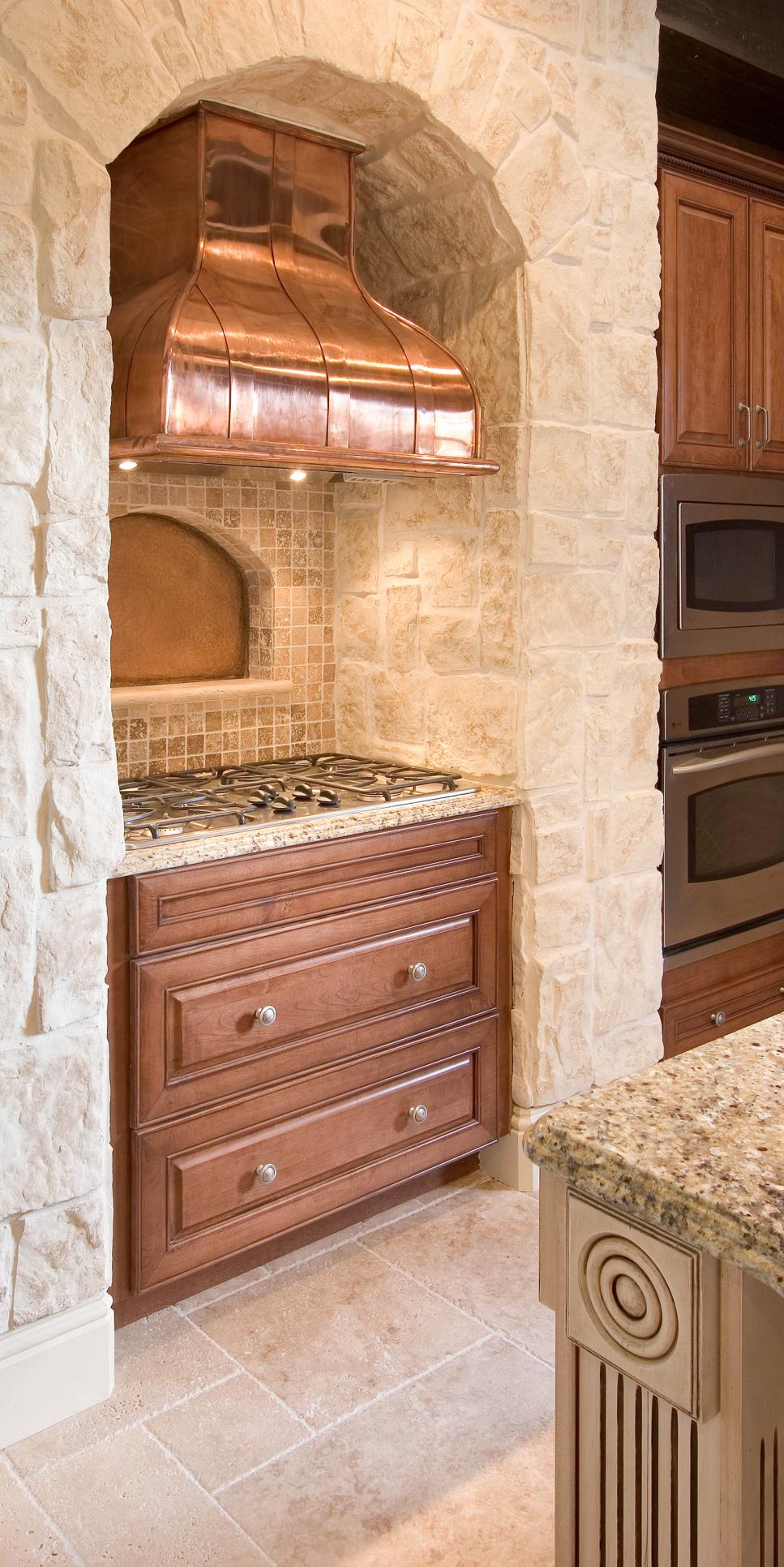 Neutral Old World Kitchen With Built-In Copper Hood in Stone Alcove