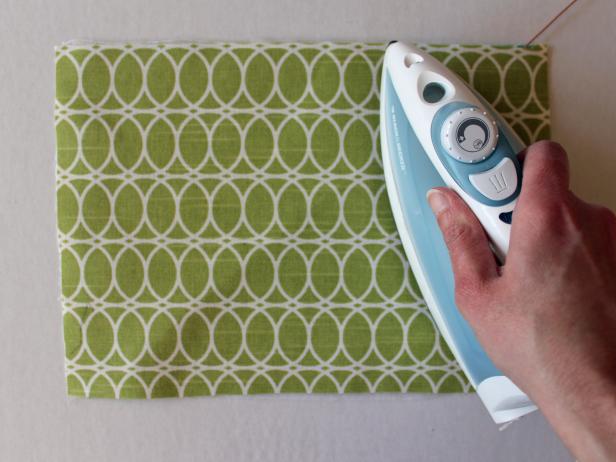 Place adhesive web side of fabric on top of a felt piece. Fuse fabric onto felt with an iron