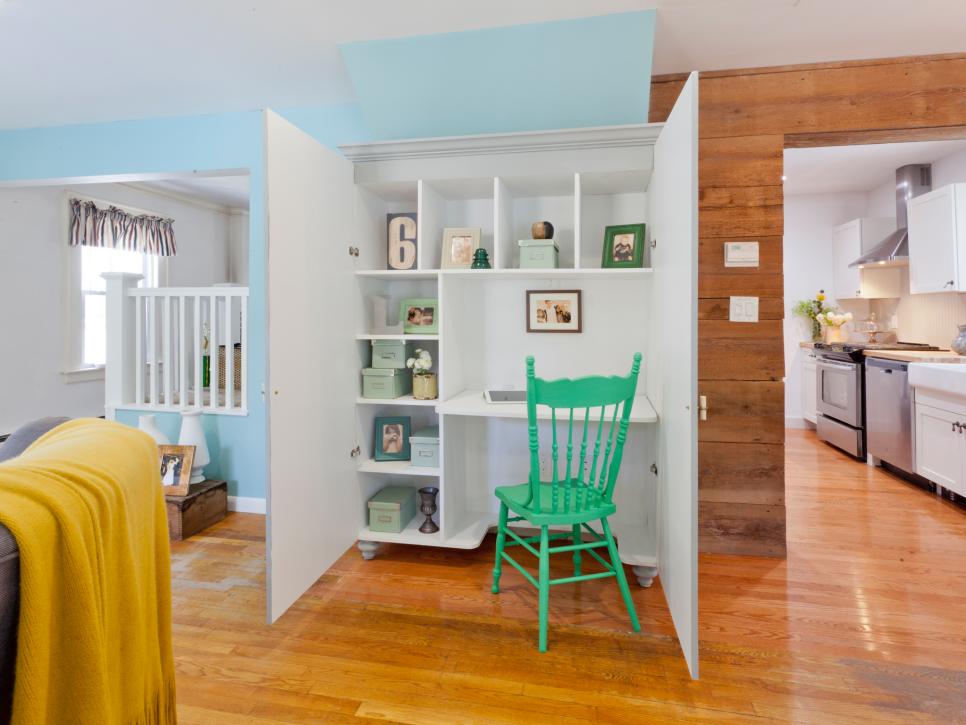 White Cabinet That Opens to Reveal Desk With Green Chair 