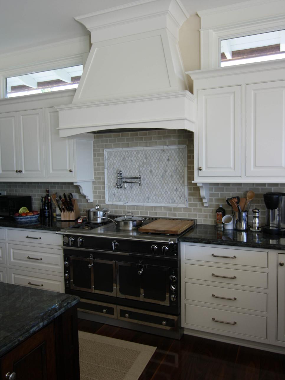 White Kitchen Cabinetry With Subway Tile and Black Stove