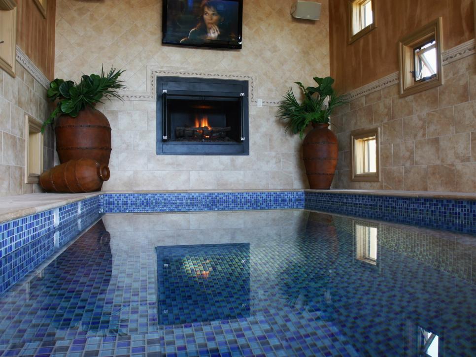 Indoor Pool With Blue Mosaic Tile and Fireplace 