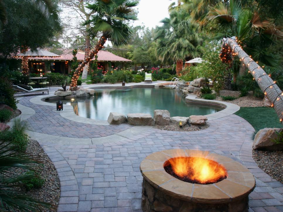Tropical Pool With Lush Landscaping and Stone Tile