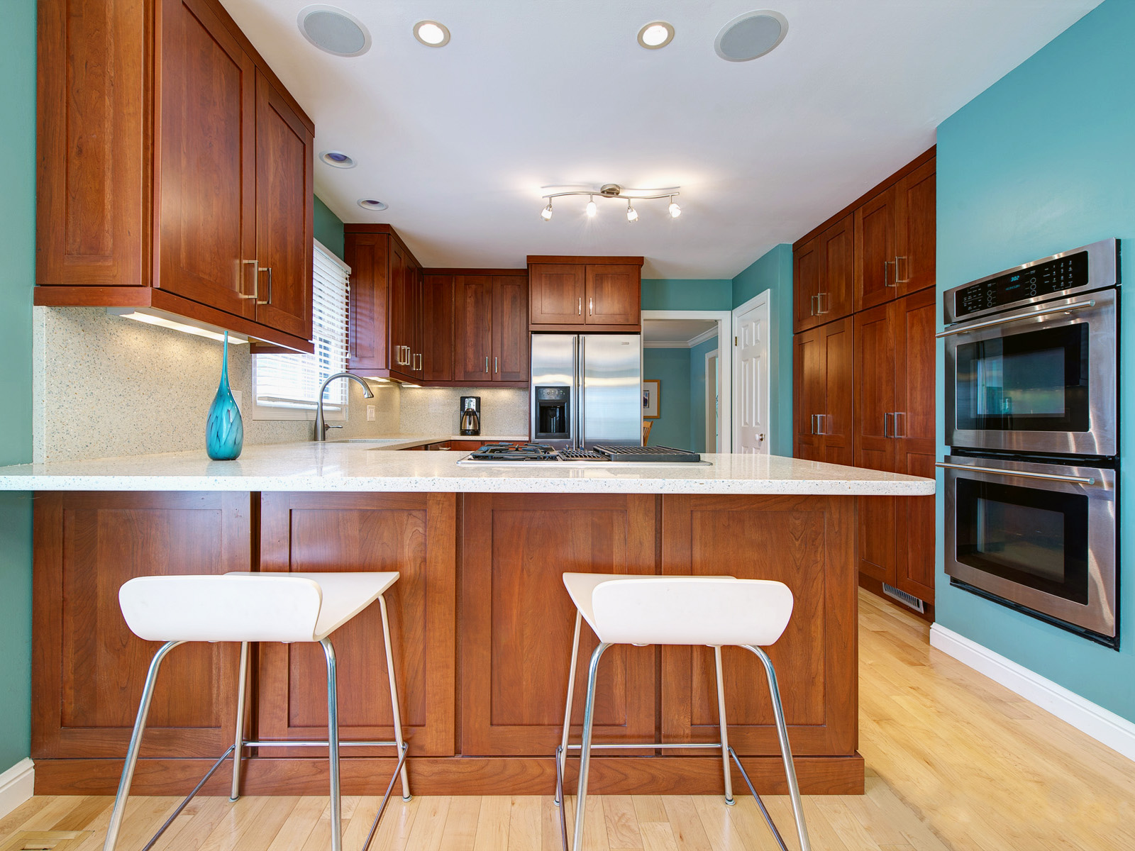 Кухня с голубыми стенами и коричневым кухонным гарнитуром