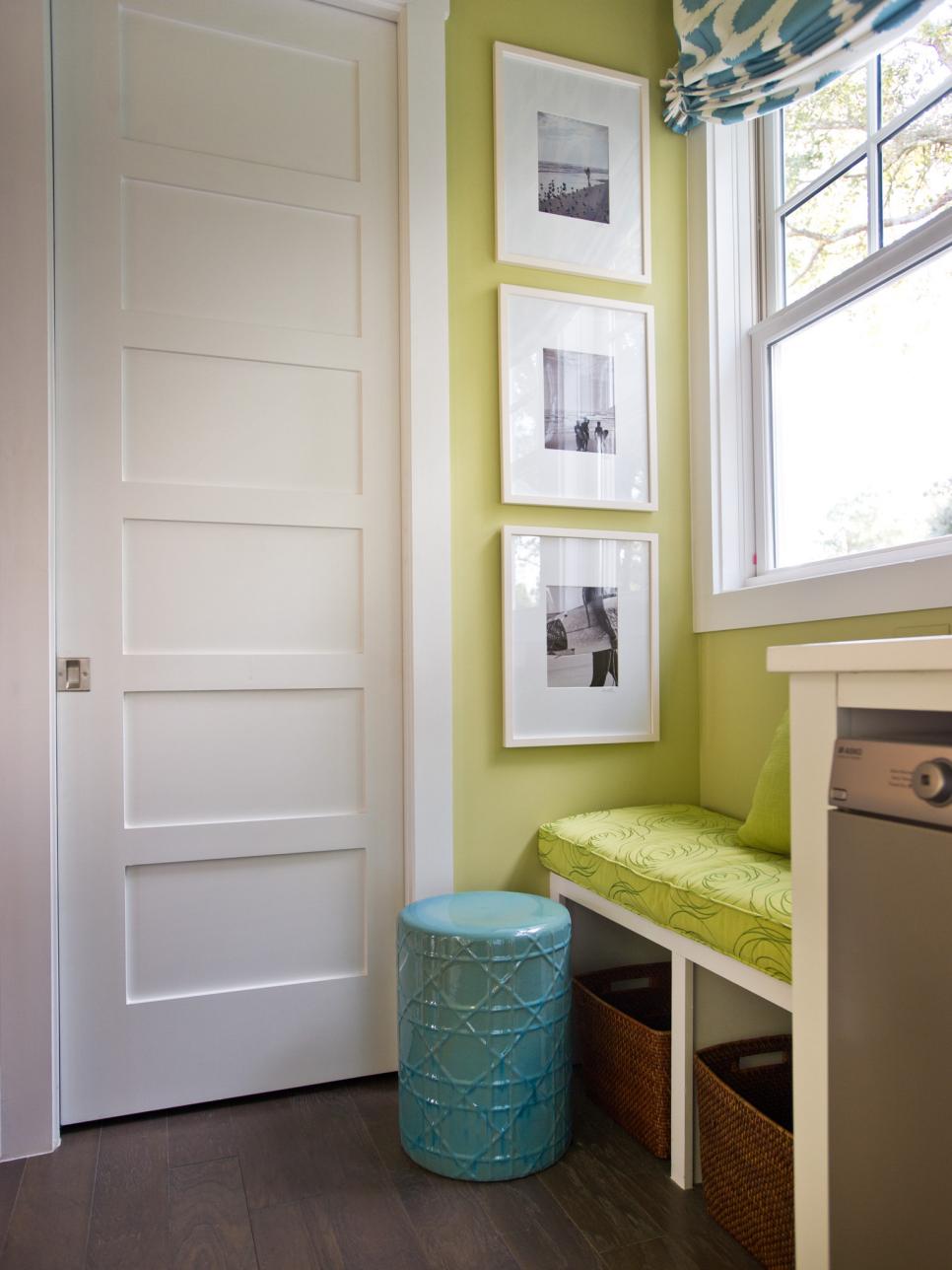 Contemporary laundry room in green and white, with built-in bench.
