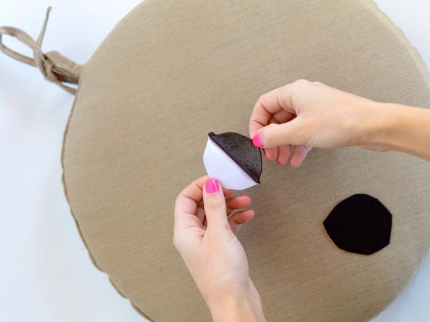 Peel sticker off felt and adhere to one side of chair cushion. Repeat on second chair cushion.