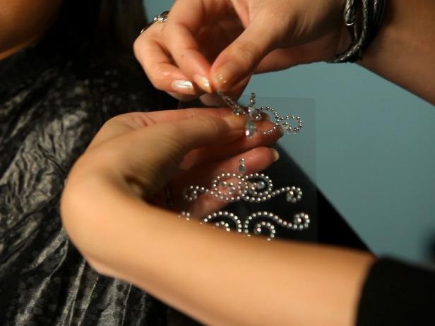 To apply fairy princess makeup, begin with a pearly eye shadow. Then add pink blush on the cheeks. Next, apply self-adhesive glittering jewels on forehead like a princess' tiara, and then apply additional jewels under eyebrows, on cheekbones or anywhere you like. Tip: You can find self-adhesive jewels in the scrapbooking section of your local craft store. Make sure your child doesn't have any adhesive allergies before continuing with this step. Keeping away from the sensitive eye area, dab face lotion on the cheeks and surrounding the jewel tiara on forehead. Have model close her eyes then apply cosmetic glitter where lotion was applied. Paint lips with a sparkly pink lipstick or tinted lip-gloss. Finish the look with a fairy princess costume.