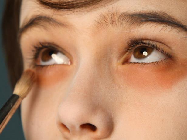 Shade under eyes by blending with brushes and eyeshadows in brown, gray, pink and red shades to make skin look sickly and sunken in.