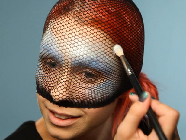 Set the creme foundation with shimmering eye shadows in similar shades. Use a fluffy eye shadow brush to lightly dust the color, mimicking the fade effect you created with the creme foundations. Start with blue eye shadow first, then fade to aqua eye shadow. Use silver/white mineral shimmer eye shadow to dust over the entire design to reflect light like real fish scales