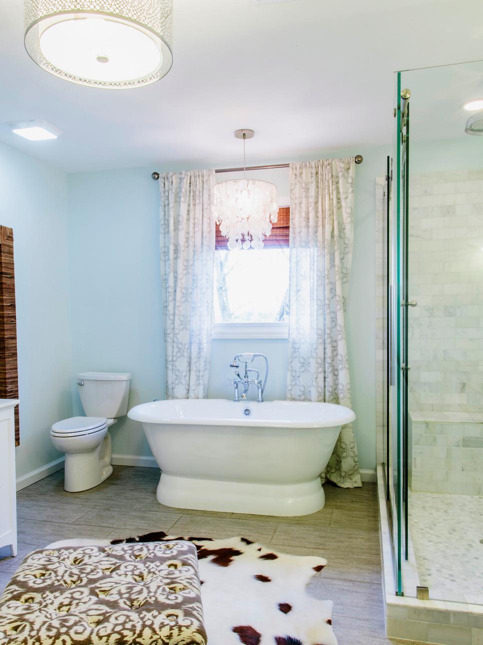 Light Blue Bathroom With Freestanding Tub and Glass Shower