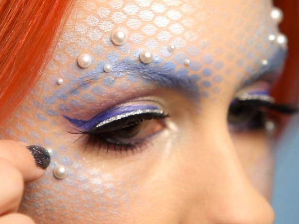 Place stick-on pearls over the scales around eyes