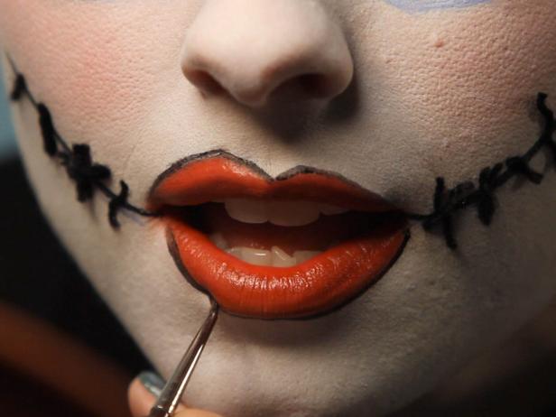 Use black liquid liner once more and line outside lips to enhance the mismatched shape youve given them.
