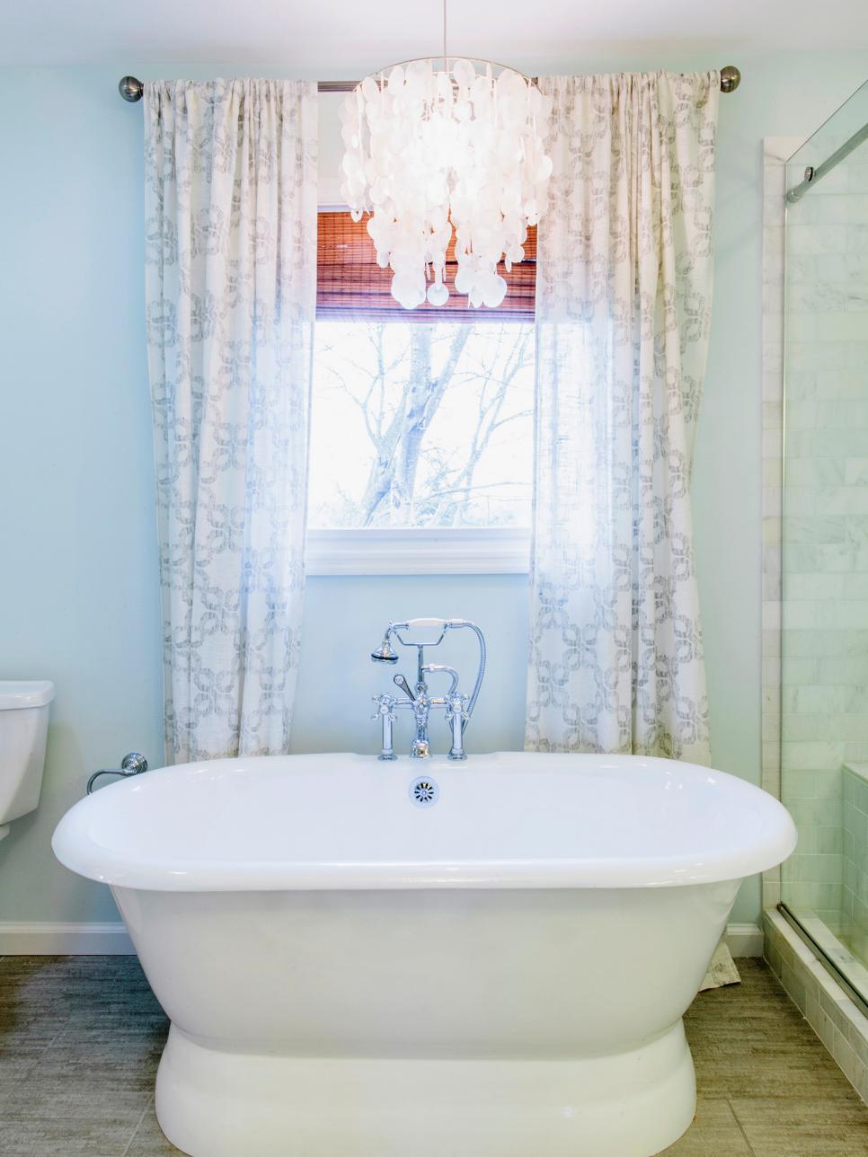 Transitional Bathroom With Freestanding Soaker Tub White Oval Tub With White Chandelier, Brown Shade and White Curtains
