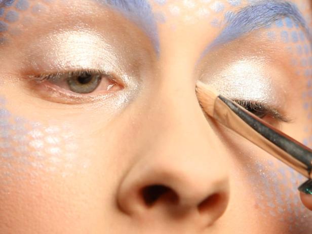Brush silver/white mineral shimmering eye shadow across eyelids and continue to the inside corners of eyes.