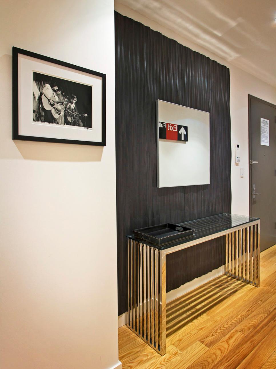 Entryway With Black Accent Wall, Glass Console Table, and Modern Art