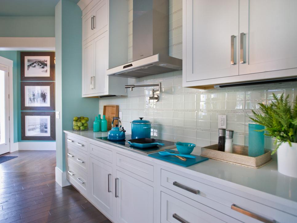 Kitchen With White Cabinetry, White Tile Backsplash & Stainless Hood