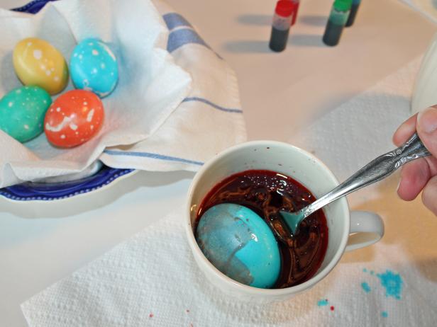 Rolling dyed Easter egg in ollive oil to marbleize it Rolling dyed Easter egg in ollive oil to marbleize it