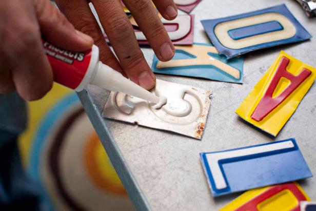 Turn each letter over onto a flat surface so the back side is facing up. Add a small bead of liquid bonding adhesive to the back, roughly 1/3 the diameter of a penny