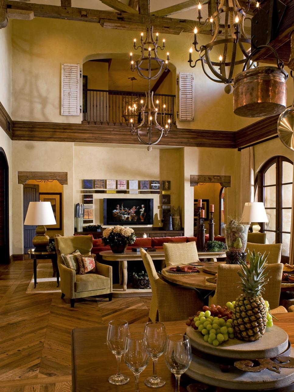 Mediterranean Family Room With Exposed Beams Neutral Den With Wood Trusses, Metal Chandeliers and Tan Furnishings
