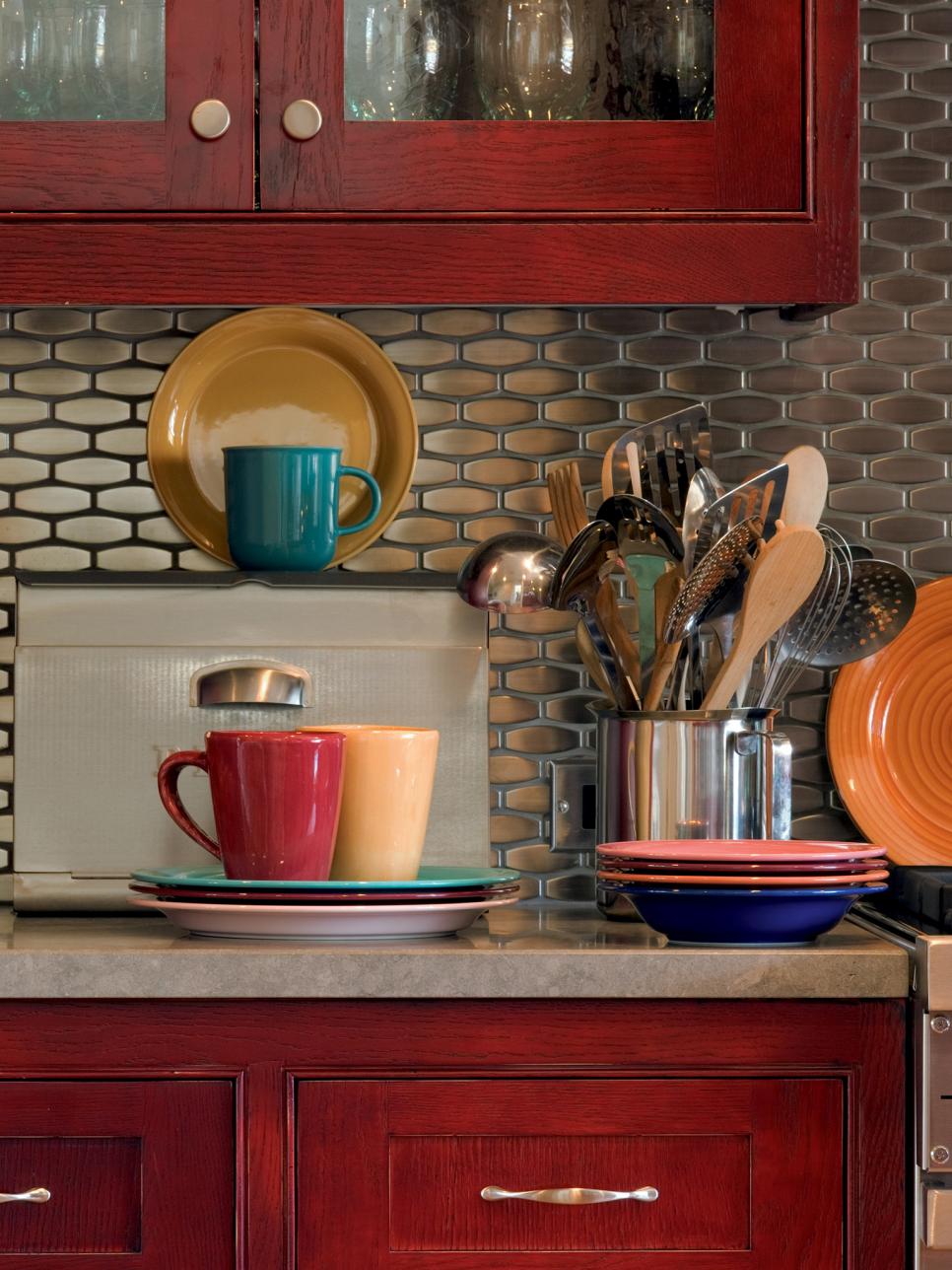 Warm Red Cabinets, Colorful Dishes, Stainless Steel Backsplash