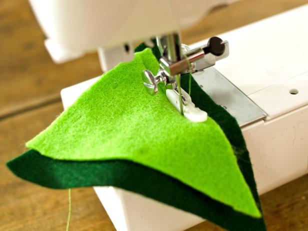 Sew triangles together with coordinating green thread. Remove pins. Pin sewn scales into slit in back of sweatshirt, leaving about a 1 inch gap. Sew along pin line. Remove Pins.