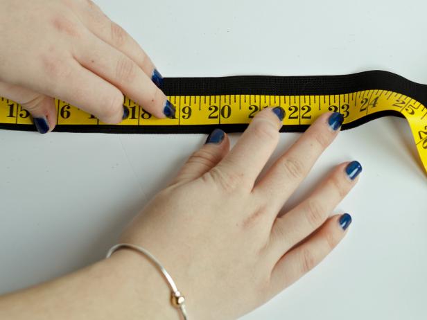 To make tutu's waistband, measure the child's waist then transfer that measurement to a black elastic band. Mark the measurement with a pencil, then cut the elastic band at the marked line.