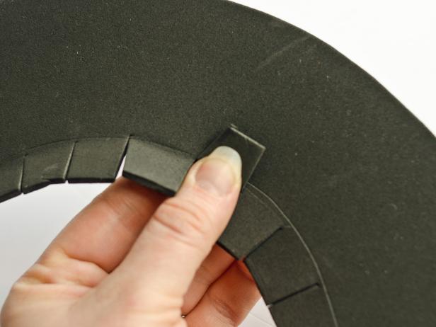 After you have set and centered the cone on top of the circle and traced the cone around it, Step 5D in making a brim for witch's hat is to cut the excess in 1/2/ inch tabs around the circle. Fold over the tabs to crease them.