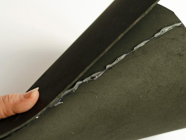 Step 4E in making a witch's hat for a child's Halloween costume is to apply a small bead of hot glue down the remainder of cone's seam and press the overlapping foam onto it. Hold the glue in place until it cools. Tip: Applying a small amount of glue will prevent squeeze-out.