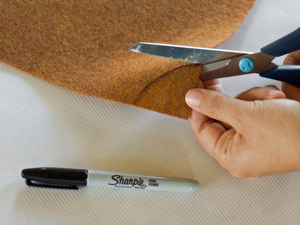 To create a nose, use a black marker to draw an arch on one corner of a felt sheet, then cut along the marked line.