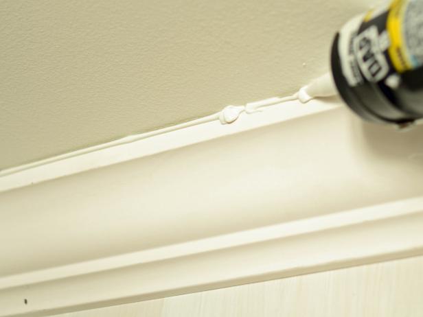 Caulking is one of the finishing touches to installing custom jobs. Fill nail holes and small seams with wood filler. Place a small amount on your fingertip and rub over a hole or seam. Using a caulk gun, apply paintable trim caulk to seams, crown and trim. Run a small bead along the seam and smooth with a wet finger or cotton cloth. Allow caulk and wood filler to dry. Sand any rough areas with heavier grit (lower-numbered) sandpaper, working to fine grit.