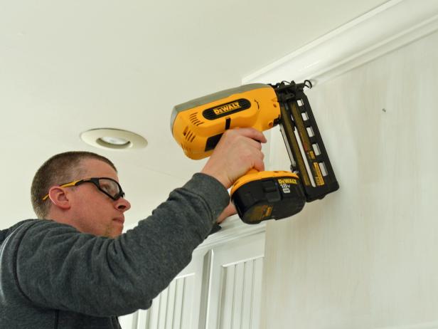 When creating a custom range hood, measure width and depth of range hood and cut crown molding to fit. Nail crown molding into place with finishing nailer. Fit two pieces together at an angle before nailing into place to ensure angle is consistent.