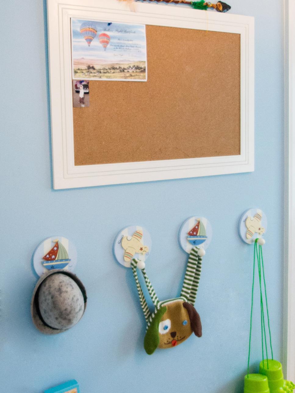 Blue Kids' Bedroom With Decorative Hooks Below Bulletin Board