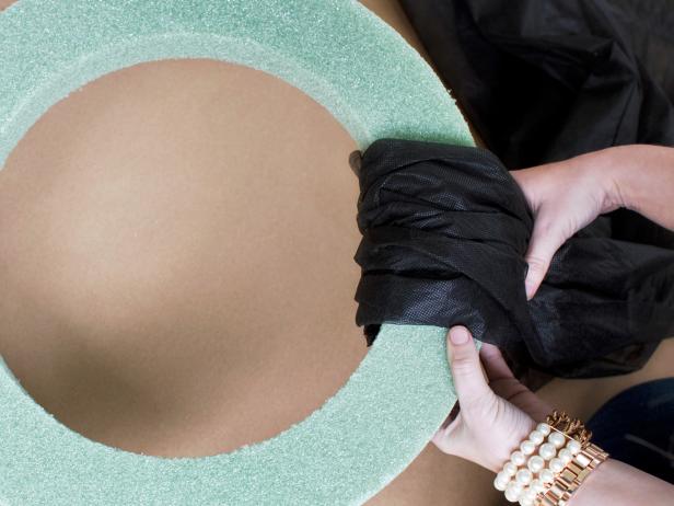 Wrap fabric around wreath form, ensuring the form is entirely covered.