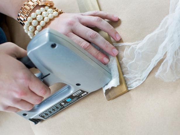 Once the cheesecloth is dry, staple the panels to the poplar strips.