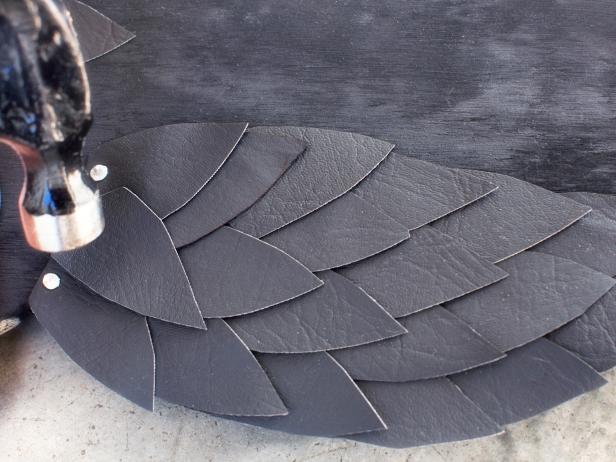 Using hammer, add a decorative row of stainless steel tacks along the top row of feathers.
