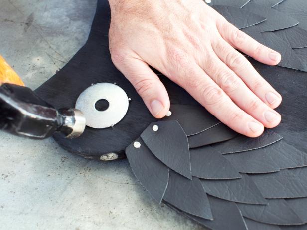 Position washers along face area of owl silhouette. Once in place, attach with picture nails around the perimeter and fastened in place with hammer.