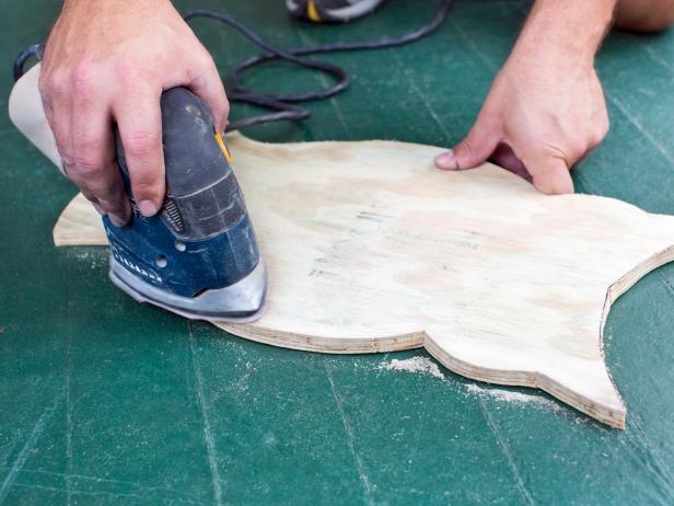 Using an orbital sander, smooth any flaws or rough spots in the plywood.