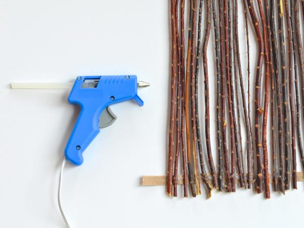 Lay twigs perpendicular across ribbons so ends are touching each ribbon. One at a time, use hot glue gun to attach twigs to ribbon until the desired length is reached. Allow natural variation in spacing for an organic look.